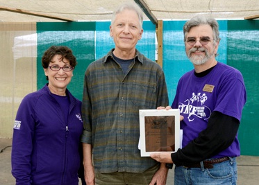 Rob Tiger (center) is congratulated by Susan Belcher, wife of WCU Chancellor David O. Belcher, and Scott Philyaw, director of WCU’s Mountain Heritage Center.